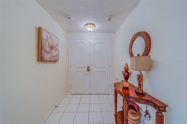 entryway with light tile patterned flooring and a textured ceiling