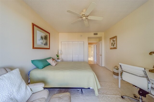 bedroom with ceiling fan, a closet, and a textured ceiling