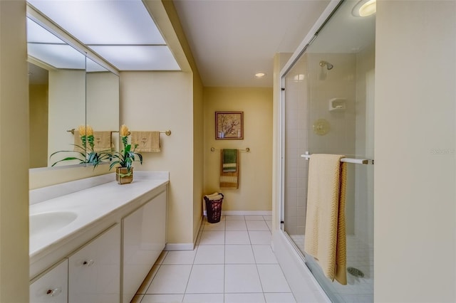 bathroom with an enclosed shower, vanity, and tile patterned flooring