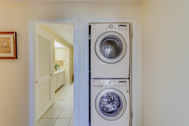 laundry area featuring stacked washing maching and dryer and light tile patterned floors