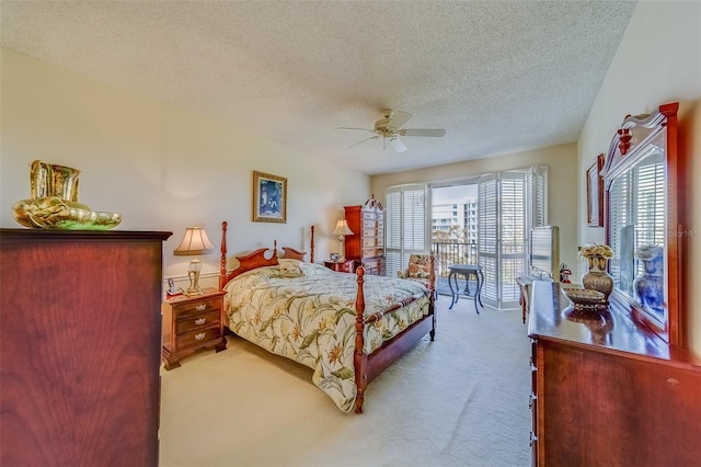 bedroom featuring ceiling fan, light colored carpet, and a textured ceiling