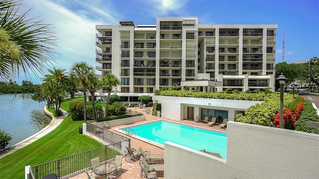 view of pool featuring a yard, a patio, and a water view