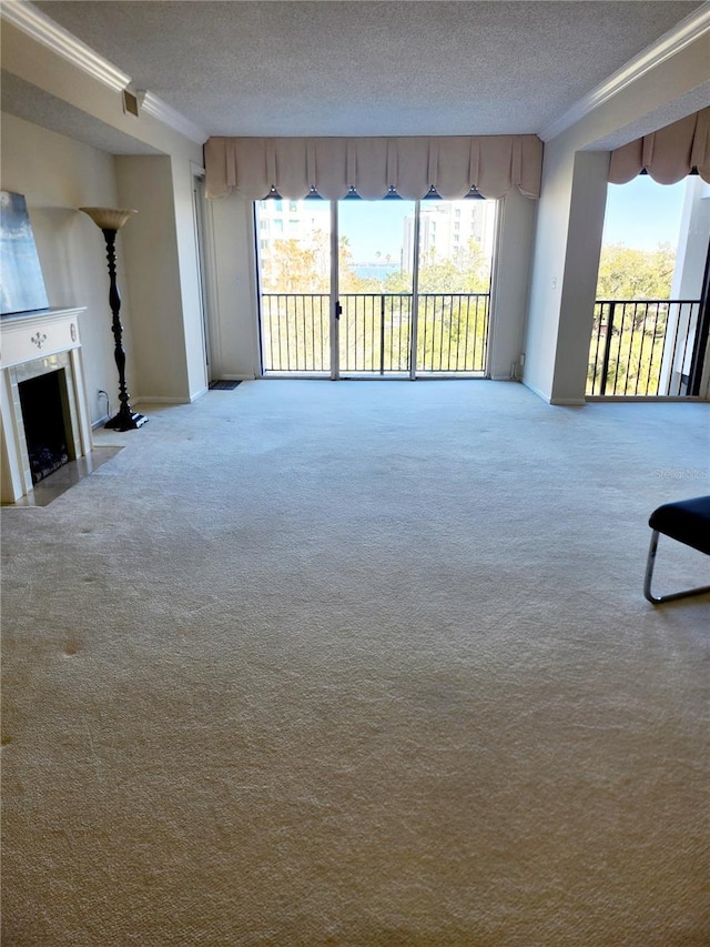 unfurnished living room with crown molding, a textured ceiling, and a wealth of natural light