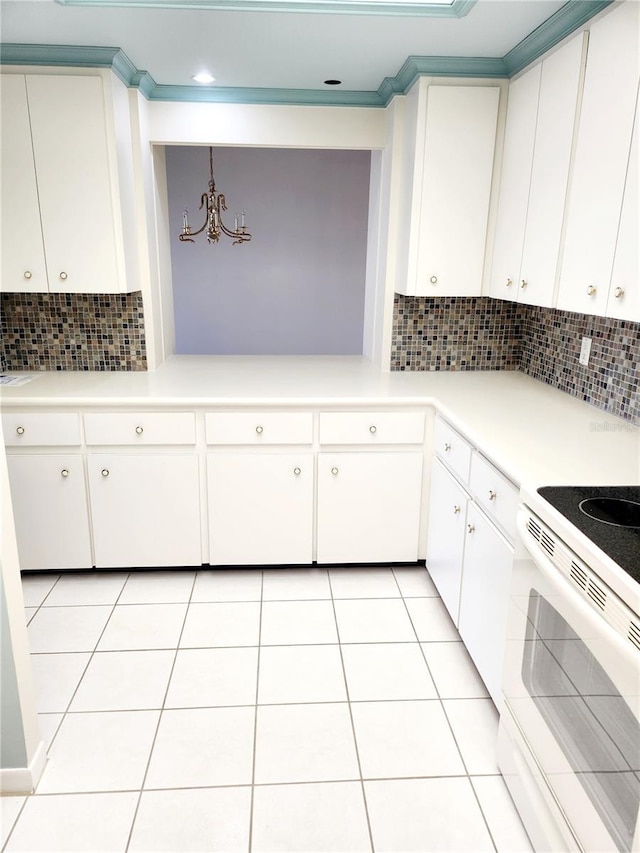 kitchen featuring tasteful backsplash, white electric range oven, hanging light fixtures, and white cabinets