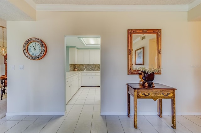 corridor with crown molding and light tile patterned floors