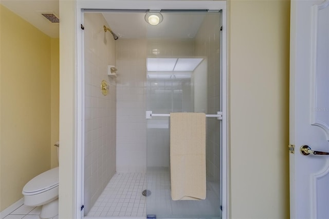 bathroom featuring a shower with shower door, tile patterned floors, and toilet