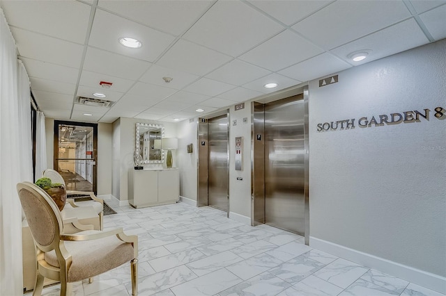 hall featuring elevator and a drop ceiling