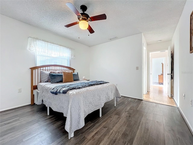 bedroom featuring a textured ceiling, dark hardwood / wood-style floors, and ceiling fan