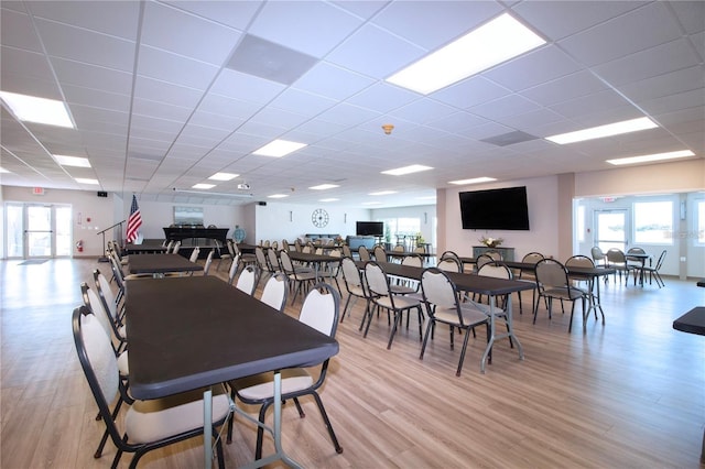 dining room featuring light hardwood / wood-style flooring and a drop ceiling