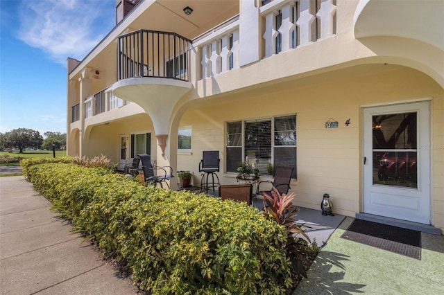 2298 Netherlands Dr Unit 4, Clearwater, FL 33763 - view of exterior entry featuring a balcony, a patio area, and stucco siding