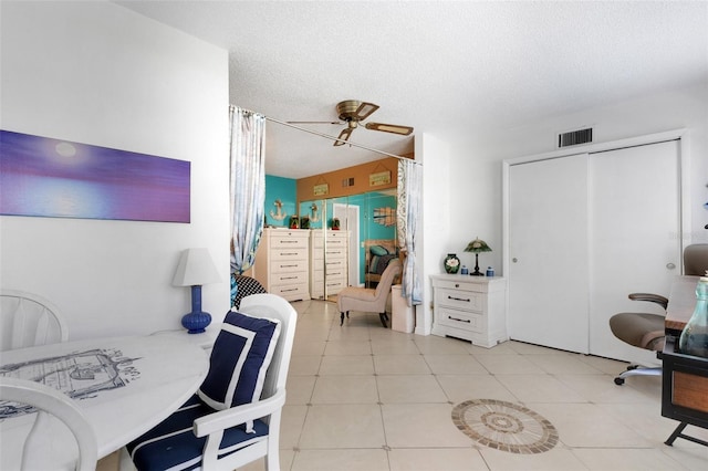 bedroom featuring ceiling fan, a textured ceiling, and light tile patterned flooring