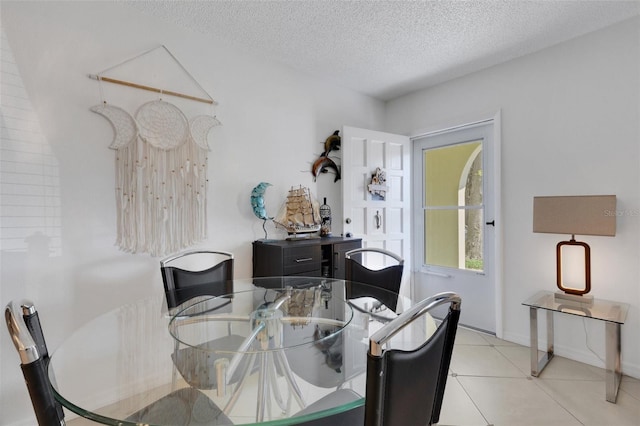 tiled dining area with a textured ceiling