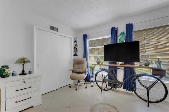 office area with a textured ceiling and a healthy amount of sunlight