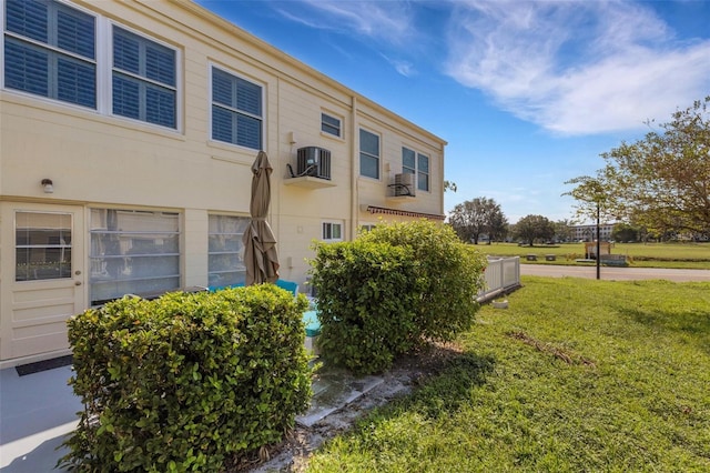 view of side of property featuring a lawn and central AC unit