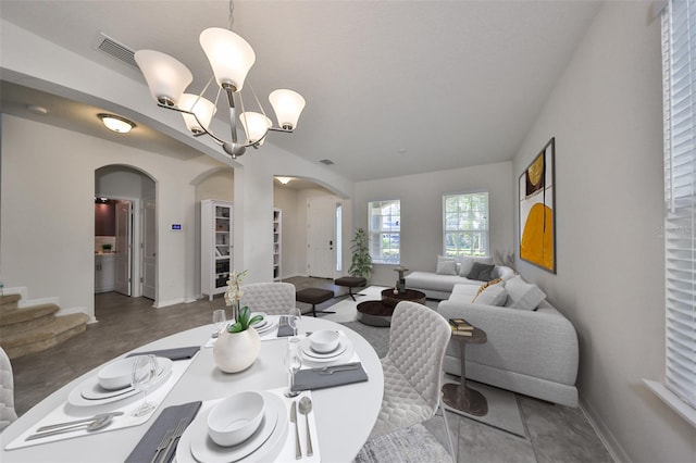 dining space featuring a notable chandelier and concrete floors