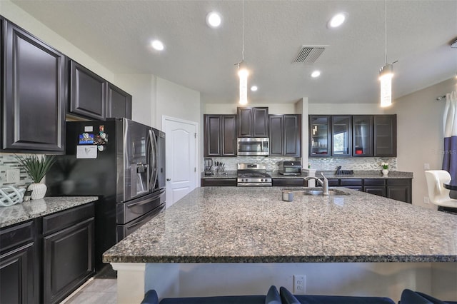 kitchen featuring a breakfast bar, appliances with stainless steel finishes, and tasteful backsplash