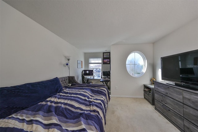 bedroom with a textured ceiling and light colored carpet