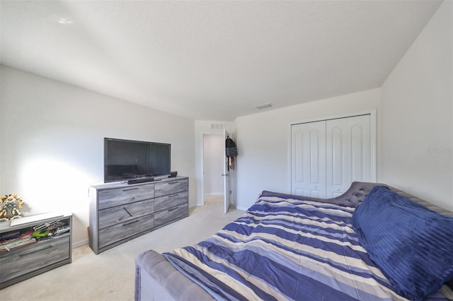 bedroom featuring a closet and light colored carpet