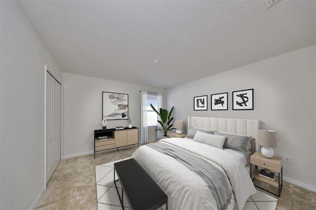 bedroom featuring a closet, light carpet, and a textured ceiling