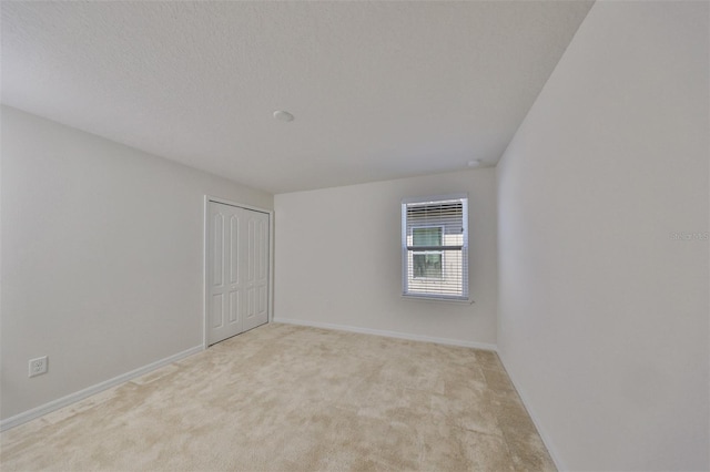 carpeted spare room featuring a textured ceiling