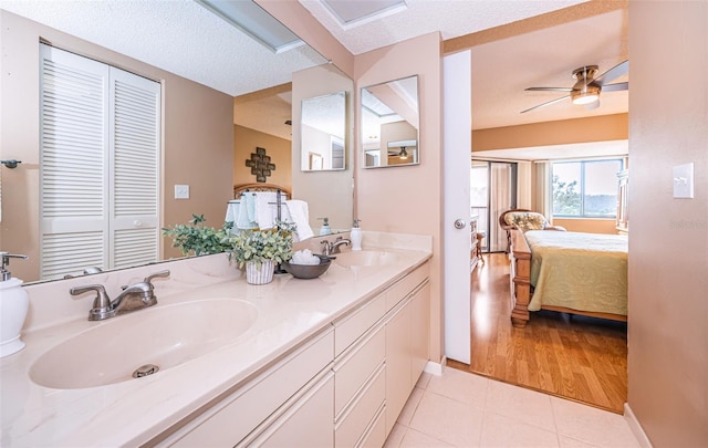 bathroom with vanity, wood-type flooring, a textured ceiling, and ceiling fan