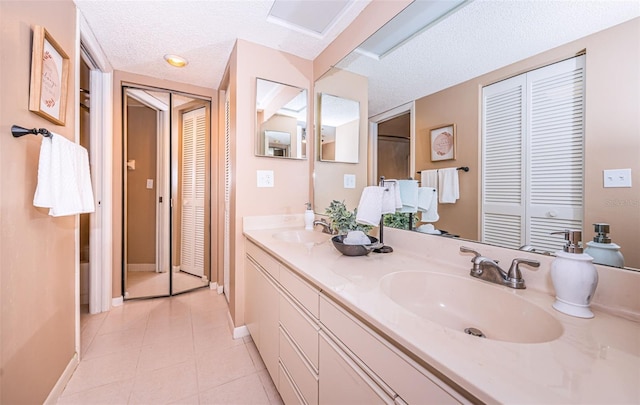 bathroom featuring vanity, a textured ceiling, and tile patterned floors