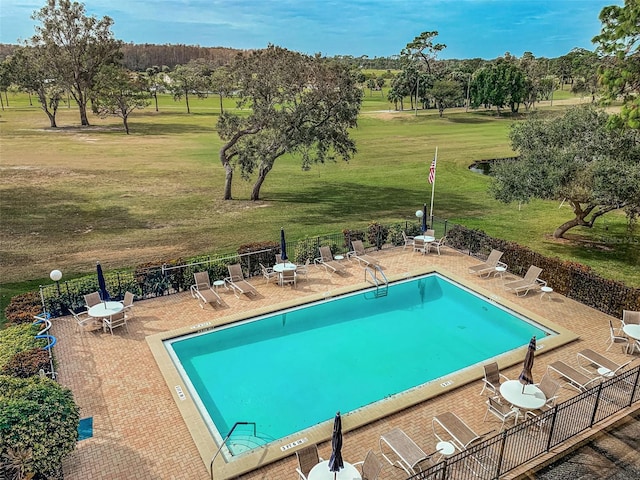 view of pool with a patio area and a yard