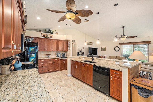 kitchen featuring light stone counters, black appliances, sink, decorative light fixtures, and a textured ceiling