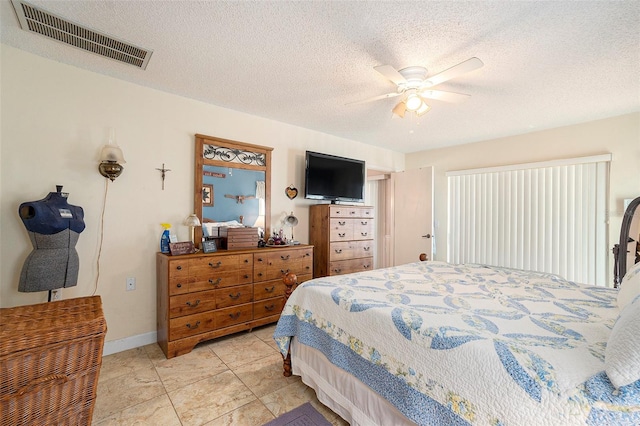 bedroom with ceiling fan, a textured ceiling, and light tile patterned floors