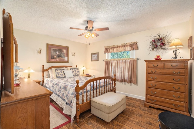 bedroom with ceiling fan, dark wood-type flooring, and a textured ceiling