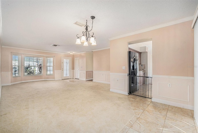 empty room featuring a chandelier, crown molding, and a textured ceiling