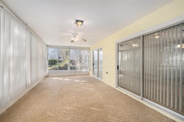 unfurnished sunroom with ceiling fan