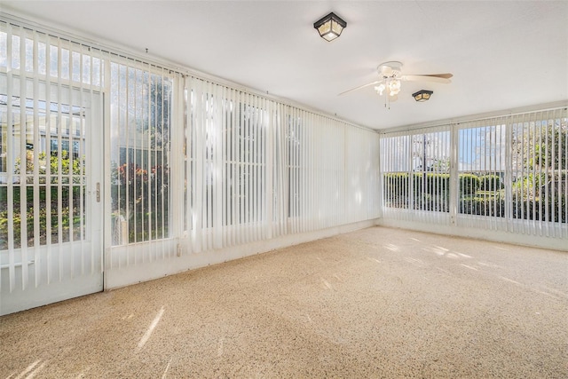 unfurnished sunroom featuring ceiling fan