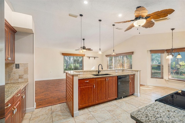 kitchen with hanging light fixtures, light stone countertops, sink, a healthy amount of sunlight, and dishwasher