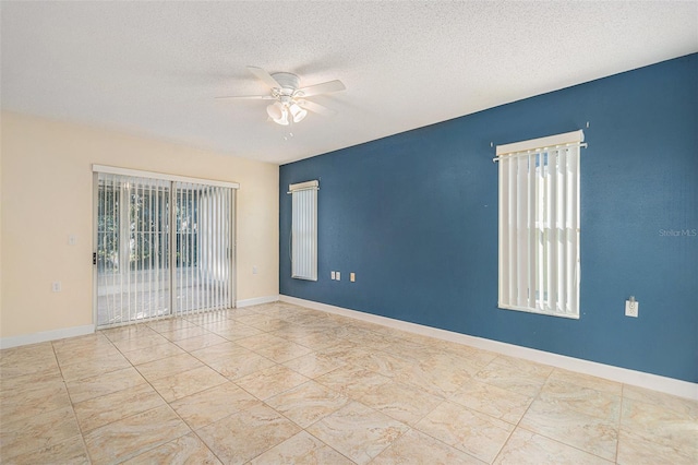 unfurnished room with ceiling fan and a textured ceiling