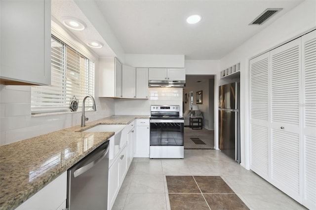 4028 Davit Dr Unit 4028, New Port Richey, FL 34652 - kitchen featuring appliances with stainless steel finishes, a sink, under cabinet range hood, light stone counters, and white cabinets