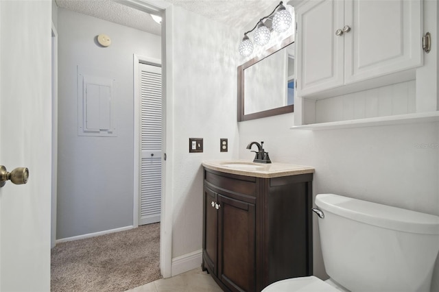 bathroom with vanity, toilet, and a textured ceiling