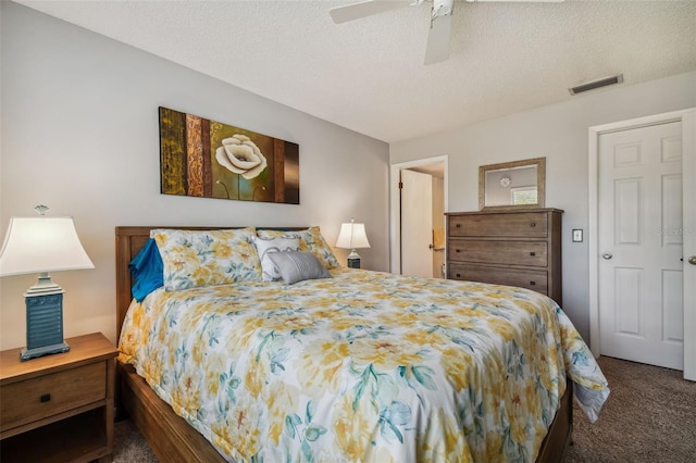 carpeted bedroom featuring ceiling fan and a textured ceiling