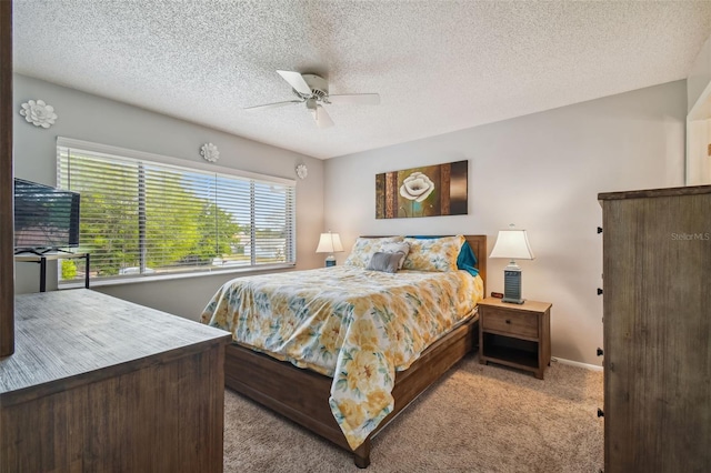 carpeted bedroom with ceiling fan and a textured ceiling