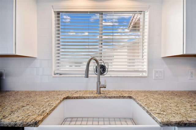 4028 Davit Dr Unit 4028, New Port Richey, FL 34652 - kitchen view of tasteful backsplash, white cabinets, a sink, and light stone countertops
