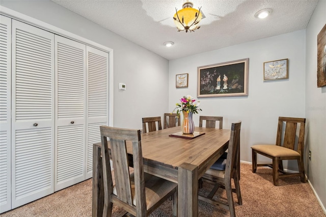 dining area with light carpet and a textured ceiling