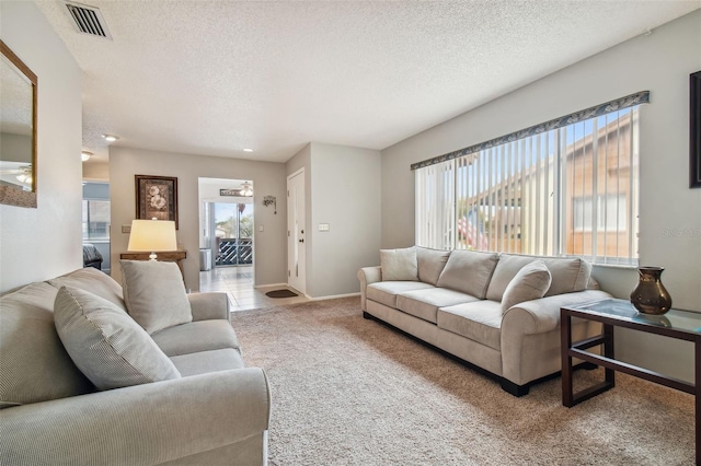 carpeted living room featuring a textured ceiling