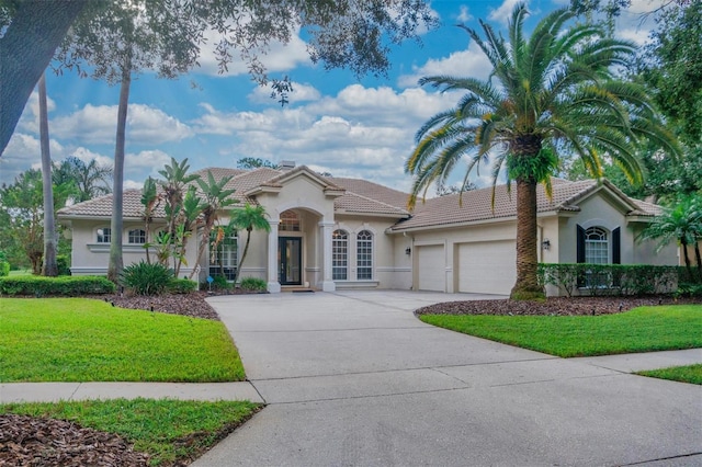 view of front of house with a garage and a front lawn