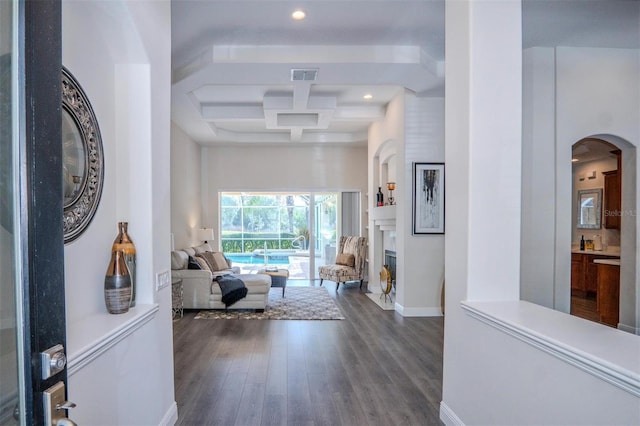 hallway featuring beamed ceiling, coffered ceiling, dark hardwood / wood-style flooring, and a high ceiling