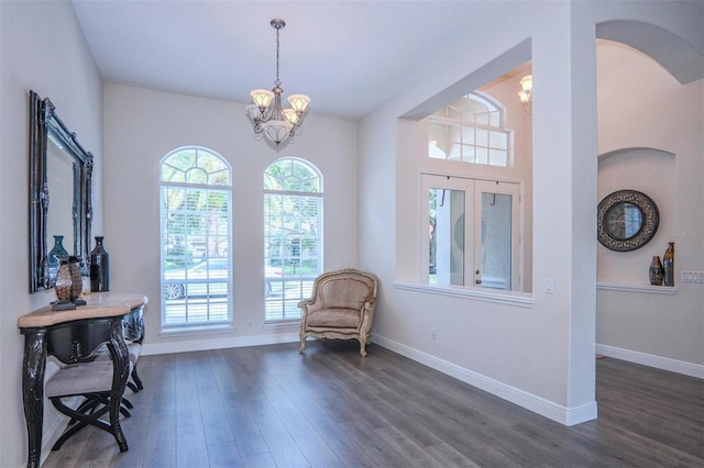 living area with dark wood-type flooring and a chandelier