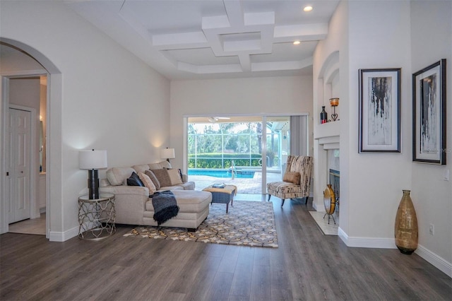 living room with dark hardwood / wood-style floors, coffered ceiling, beam ceiling, and a high ceiling