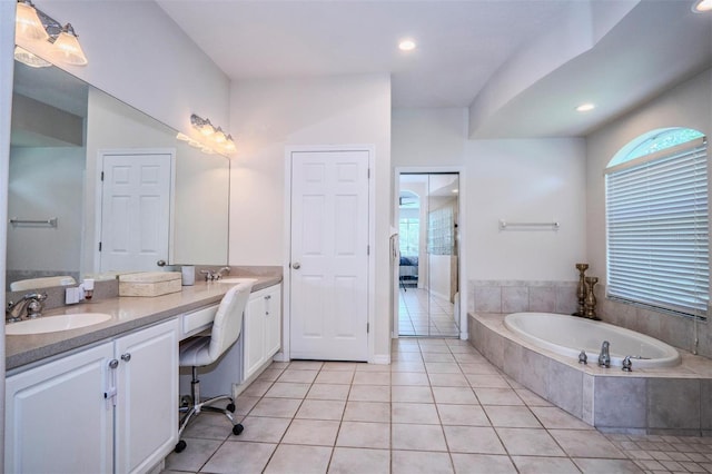 bathroom featuring vanity, tiled tub, and tile patterned floors