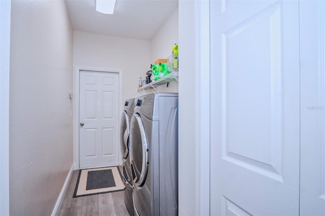 clothes washing area with hardwood / wood-style flooring and independent washer and dryer