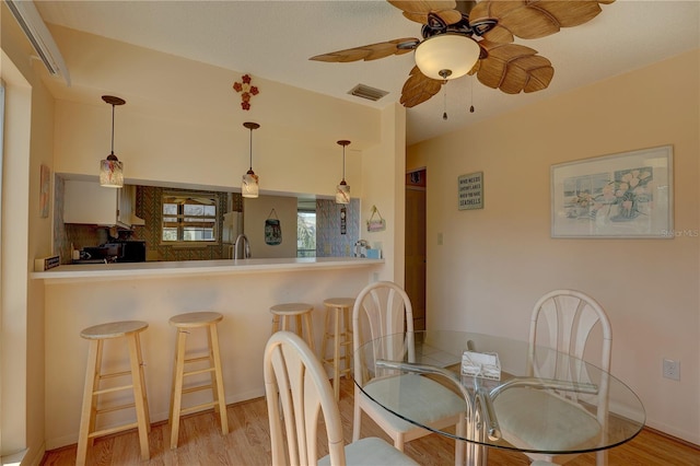 dining space with light hardwood / wood-style flooring and ceiling fan