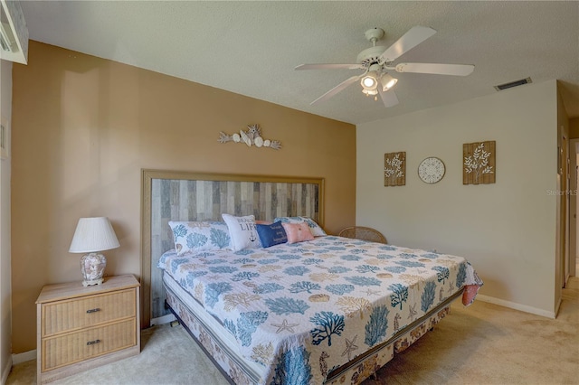 carpeted bedroom with ceiling fan and a textured ceiling